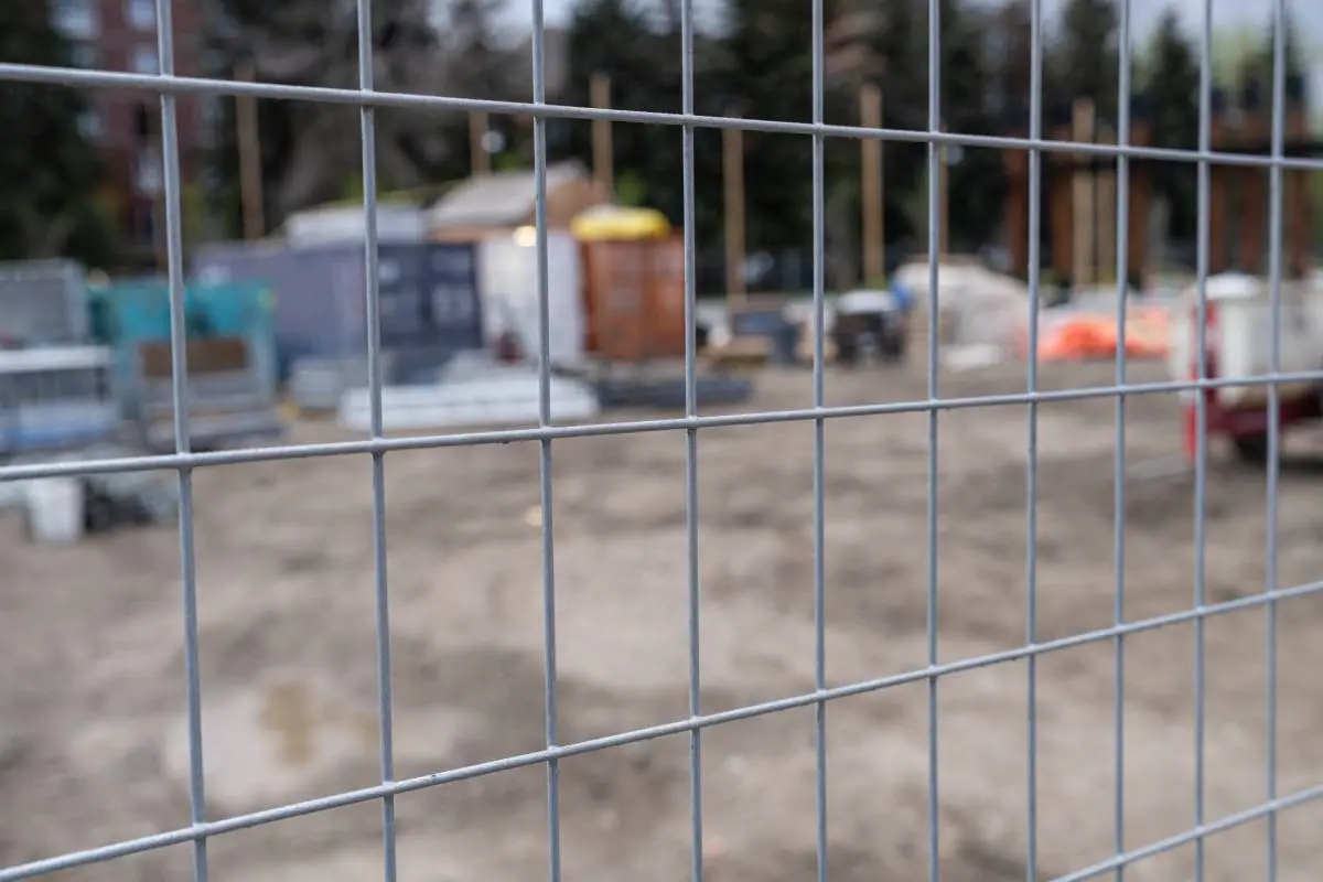 Construction site behind chain link wire fence in Calgary